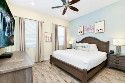 a bedroom with a bed and a ceiling fan at Seashell Cream Cottage With Private Pool Near Disney With Margaritaville Resort & Island H2O Access - 8037St in Orlando