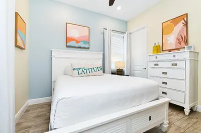 a bedroom with a white bed and a dresser at Seashell Cream Cottage With Private Pool Near Disney With Margaritaville Resort & Island H2O Access - 8037St in Orlando