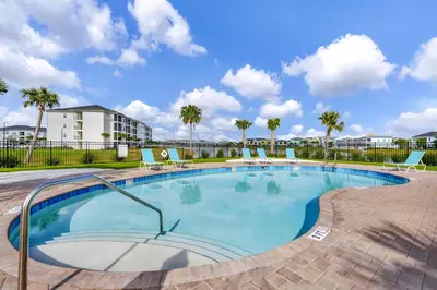 a large swimming pool with chairs and palm trees at Pearly White Villa Near Disney With Margaritaville Resort & Island H20 Waterpark Access - 2924Cs in Orlando