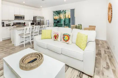 a living room with a white couch and a table at Pearly White Villa Near Disney With Margaritaville Resort & Island H20 Waterpark Access - 2924Cs in Orlando