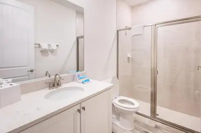 a white bathroom with a toilet and a shower at Pearly White Villa Near Disney With Margaritaville Resort & Island H20 Waterpark Access - 2924Cs in Orlando