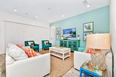 a living room with white furniture and blue walls at This Pink Cottage Near Disney With Margaritaville Resort & Island H20 Access - 8141Su in Orlando