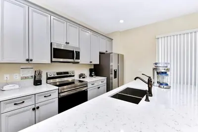 a kitchen with white cabinets and a white counter top at Breezy Blue Villa Near Disney With Margaritaville Resort & Island H20 Waterpark Access - 2997Cs in Orlando