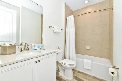 a white bathroom with a toilet and a sink at Breezy Blue Villa Near Disney With Margaritaville Resort Access - 3120Cs in Orlando