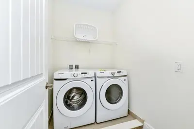 a washer and dryer in a white laundry room at Blossom Villa Near Disney With Margaritaville Resort And Island H20 Waterpark Access - 2911Cl in Orlando