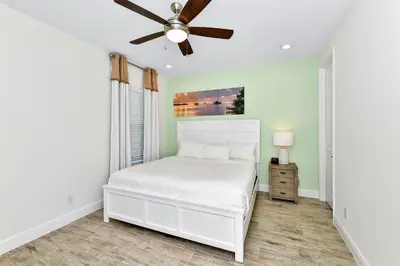 a bedroom with a white bed and a ceiling fan at Blossom Villa Near Disney With Margaritaville Resort And Island H20 Waterpark Access - 2911Cl in Orlando