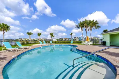 a large swimming pool with chairs and palm trees at Flip Flops & Fairytales Waterfront With Margaritaville Resort & Island H2O & Island H2O Access - 3021Cs in Orlando