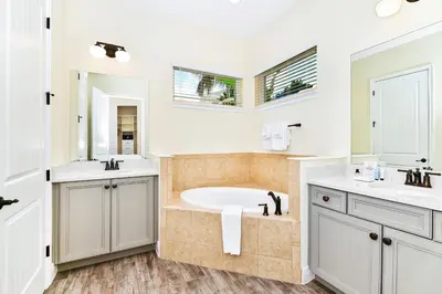 a bathroom with a tub and two sinks and a mirror at Beautiful Cottage With Hot Tub Near Disney With Margaritaville Resort & Island H2O Access - 8053Ls in Orlando