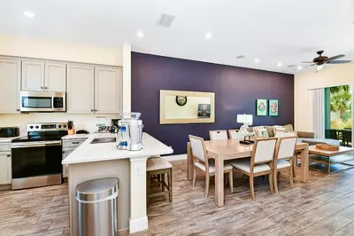 a kitchen and dining room with a table and chairs at Beautiful Cottage With Hot Tub Near Disney With Margaritaville Resort & Island H2O Access - 8053Ls in Orlando