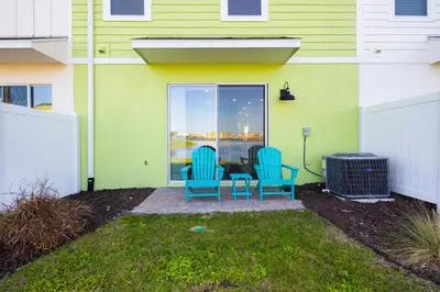 a patio with two chairs and a table in front of a house at Lime Green Villa Near Disney With Margaritaville Resort & Island H20 Waterpark Access - 2944Or in Orlando