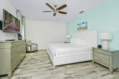 a bedroom with a white bed and a ceiling fan at Beautiful Villa Near Disney With Margaritaville Resort & Island H20 Waterpark Access - 2976Cs in Orlando