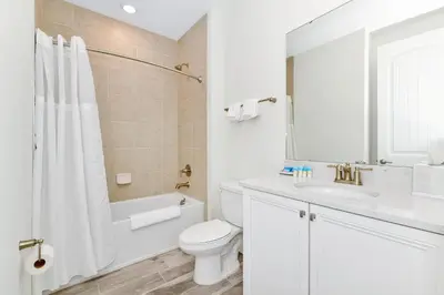 a white bathroom with a toilet and a sink at Key Lime Villa Near Disney With Margaritaville Resort & Island H20 Waterpark Access - 3073Cs in Orlando