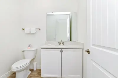 a white bathroom with a toilet and a sink at Lovely Villa Near Disney With Margaritaville Resort & Island H20 Access - 8146Cp in Orlando