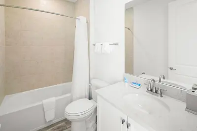 a white bathroom with a toilet and a sink at Lovely Villa Near Disney With Margaritaville Resort & Island H20 Access - 8201Su in Orlando