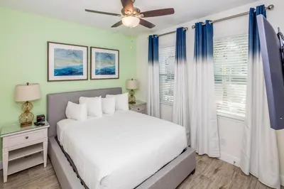 a bedroom with a white bed and a ceiling fan at Beautiful Villa Near Disney With Margaritaville Resort & Island H20 Waterpark Access - 2933Cs in Orlando