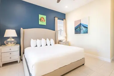 a bedroom with a white bed and a blue wall at Shore To Please Cottage Near Disney With Margaritaville Resort & Island H2O Access - 3044Sp in Orlando