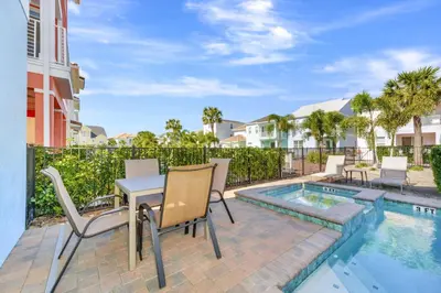a patio with a table and chairs next to a pool at Spectacular Cottage With Private Pool Near Disney With Margaritaville Resort & Island H2O Access - 8026Kd in Orlando