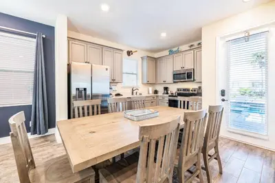 a kitchen and dining room with a wooden table and chairs at Spectacular Cottage With Private Pool Near Disney With Margaritaville Resort & Island H2O Access - 8026Kd in Orlando