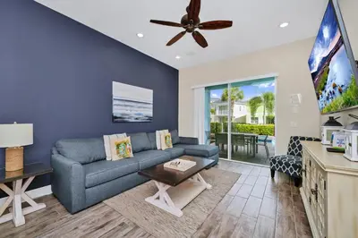a living room with a blue couch and a ceiling fan at Aqua Blue Cottage Near Disney With Margaritaville Resort & Island H20 Waterpark Access - 2930Sr in Orlando