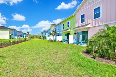 a row of colorful houses on a lawn at Colorful Villa Near Disney With Margaritaville Resort & Island H20 Waterpark Access - 3140Cs in Orlando
