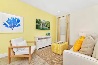 a living room with a couch and a chair at Colorful Villa Near Disney With Margaritaville Resort & Island H20 Waterpark Access - 3140Cs in Orlando