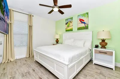 a bedroom with a white bed and a ceiling fan at Colorful Villa Near Disney With Margaritaville Resort & Island H20 Waterpark Access - 3140Cs in Orlando
