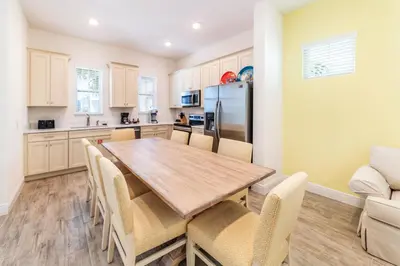 a kitchen and dining room with a wooden table and chairs at Sunkissed Cottage With Hot Tub Near Disney With Margaritaville Resort & Island H2O Access - 8046Su in Orlando