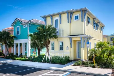 a house with palm trees in front of a street at Sunkissed Cottage With Hot Tub Near Disney With Margaritaville Resort & Island H2O Access - 8046Su in Orlando