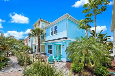 a blue house with palm trees in front of it at Orange Blossom Special Cottage Near Disney With Private Hot Tub & Island H20 Waterpark Access - 3071Pi in Orlando
