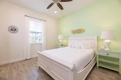 a bedroom with a white bed and a window at Kokomo Cottage Near Disney With Margaritaville Resort & Island H2O Access - 8034Su in Orlando