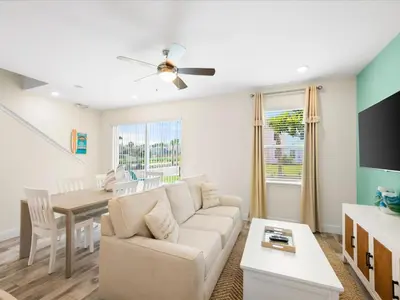 a living room with a couch and a table at Breezy Blue Villa Near Disney With Margaritaville Resort And Island H20 Waterpark Access - 2902Cl in Orlando