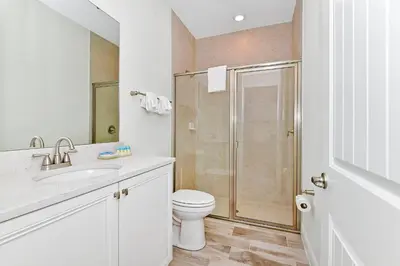 a white bathroom with a toilet and a shower at Sea Blue Villa Near Disney With Margaritaville Resort & Island H20 Access - 3164Cs in Orlando