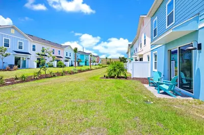 a row of houses with a green bench in a yard at Sea Blue Villa Near Disney With Margaritaville Resort & Island H20 Access - 3164Cs in Orlando