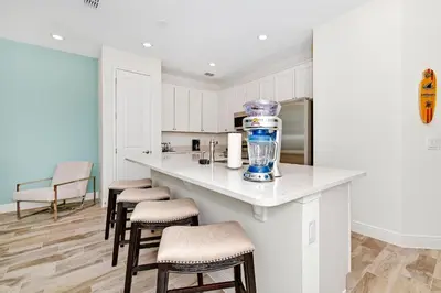 a kitchen with white cabinets and a counter with stools at Sea Blue Villa Near Disney With Margaritaville Resort & Island H20 Access - 3164Cs in Orlando