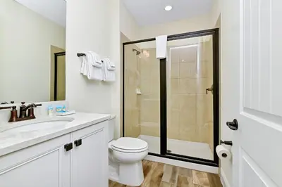 a white bathroom with a toilet and a shower at Sunshine Cottage With Private Pool Near Disney With Margaritaville Resort & Island H20 Access - 8165Su in Orlando