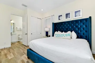 a bedroom with a large bed with a blue headboard at Sunshine Cottage With Private Pool Near Disney With Margaritaville Resort & Island H20 Access - 8165Su in Orlando