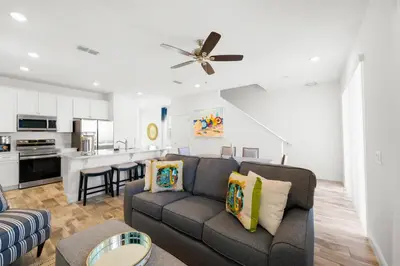 a living room with a couch and a kitchen at Lime Green Villa Near Disney With Margaritaville Resort & Island H20 Waterpark Access - 2965Cs in Orlando