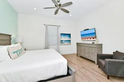 a bedroom with a bed and a couch and a ceiling fan at Paradise Cottage With Private Pool Near Disney With Margaritaville Resort & Island H2O Access - 8085Su in Orlando