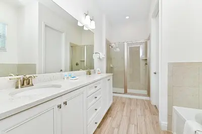 a white bathroom with two sinks and a shower at Paradise Cottage With Private Pool Near Disney With Margaritaville Resort & Island H2O Access - 8085Su in Orlando