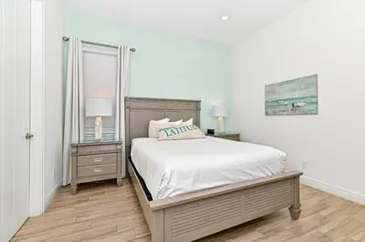 a white bedroom with a bed and two night stands at Paradise Cottage With Private Pool Near Disney With Margaritaville Resort & Island H2O Access - 8085Su in Orlando