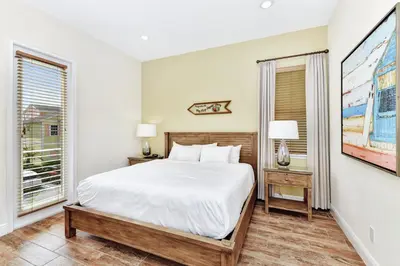 a bedroom with a large bed and two windows at The Pearl Cottage Near Disney With Margaritaville Resort & Island H20 Waterpark Access - 3078Pi in Orlando