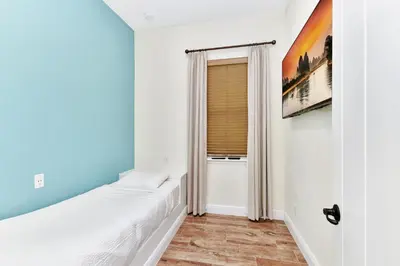 a bedroom with blue walls and a window at The Pearl Cottage Near Disney With Margaritaville Resort & Island H20 Waterpark Access - 3078Pi in Orlando