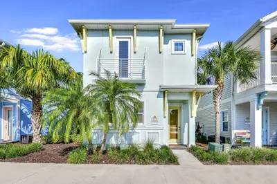 a white house with palm trees in front of it at The Pearl Cottage Near Disney With Margaritaville Resort & Island H20 Waterpark Access - 3078Pi in Orlando