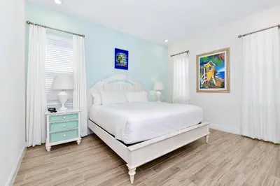 a bedroom with a white bed and a blue wall at The Shark Tank Cottage With Private Pool Near Disney & Margaritaville Resort & Island H20 Waterpark Access - 3084Ph in Orlando