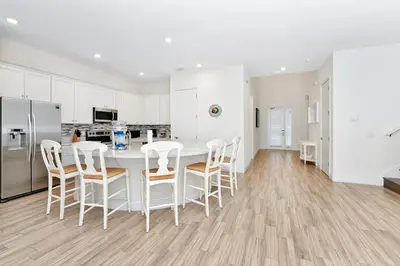 a white kitchen with a white table and chairs at The Shark Tank Cottage With Private Pool Near Disney & Margaritaville Resort & Island H20 Waterpark Access - 3084Ph in Orlando