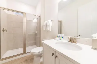 a bathroom with a toilet and a sink and a shower at Peachside Cottage Near Disney With Margaritaville Resort & Island H2O Access - 8037Dr in Orlando