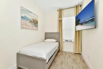 a small bedroom with a bed and a tv at Serene Villa Near Disney With Margaritaville Resort Island H20 Access - 8167Cp in Orlando