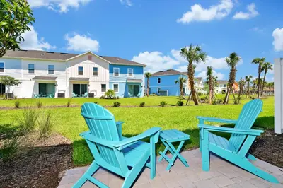 two blue chairs and a table in front of a house at Welcoming Villa Near Disney With Margaritaville Resort & Island H20 Waterpark Access - 2943Cl in Orlando