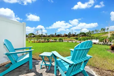 two blue chairs and a table on a patio at Paradise Villa Near Disney With Margaritaville Resort & Island H20 Access - 8186Cp in Kissimmee