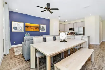 a dining room and living room with a table and chairs at Breezy Blue Villa Near Disney With Margaritaville Resort & Island H20 Waterpark Access - 2952Cs in Orlando